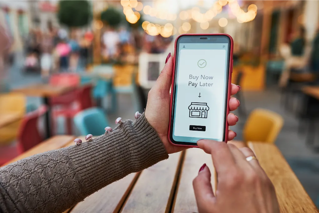 Person using Buy Now Pay Later to buy everyday essentials like food and fuel, representing rising cost of living pressure.